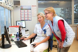 Sairaanhoitaja Sari Heikkonen esittelee Armi Vuorelle poliklinikan  kävijätilannetta.