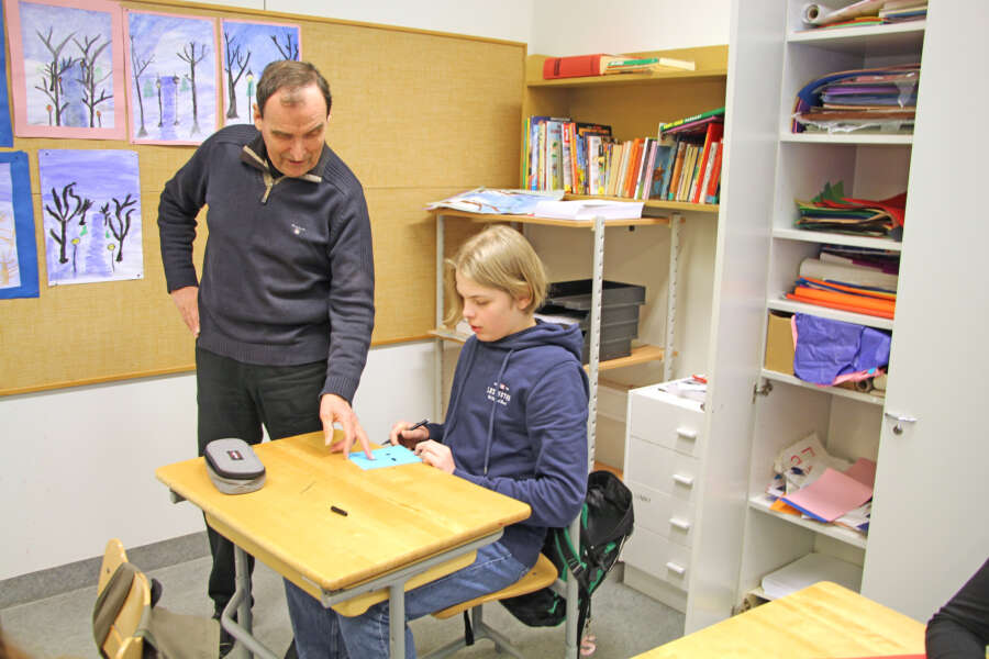 Kouluvaari Pekka Saarnivaara opastaa kuudesluokkalaista Heikki Nurmea ystävänpäiväkortin teossa.