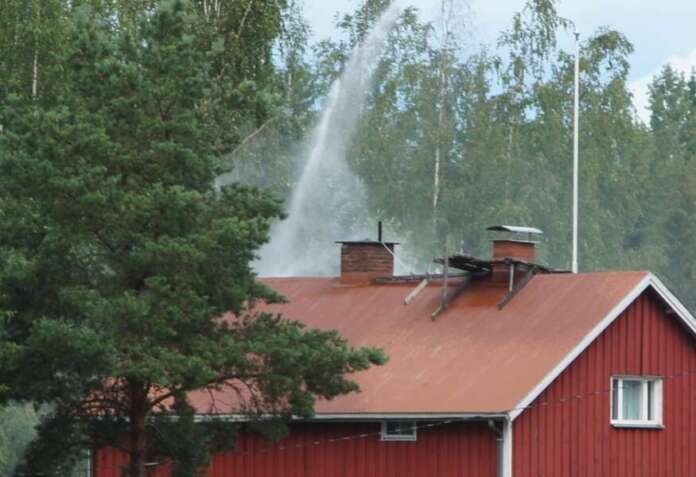 Pelastajat suihkuttivat vettä talon kattorakenteisiin. Kuva: Simo Päivärinta.