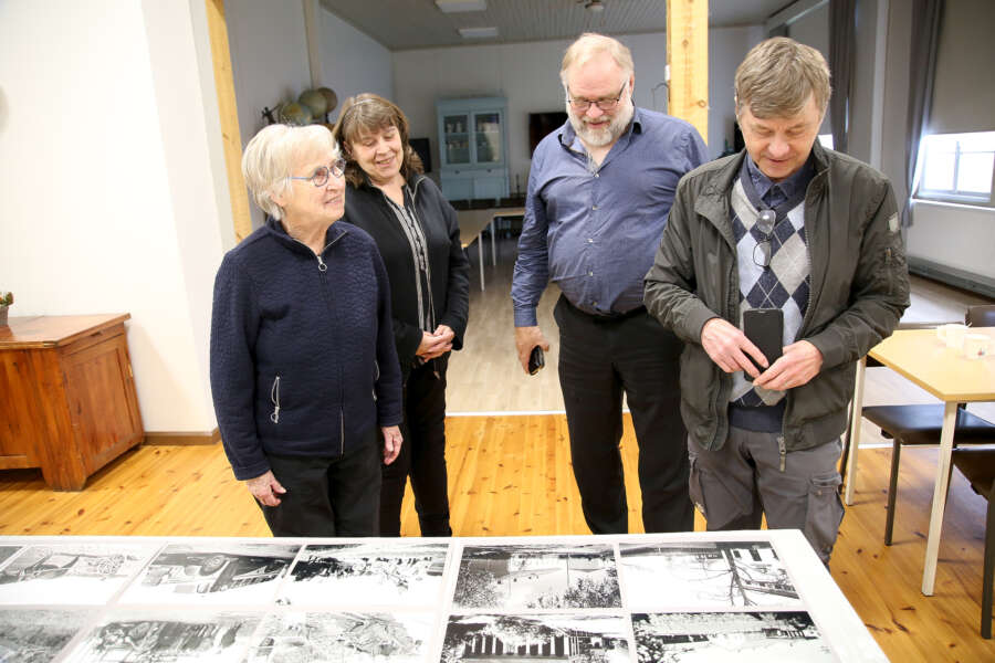 Tourulan-Keihäskosken kyläyhdistyksen historiatoimikunnan Hanna-Leena Kaihola (vas.), Tuija Olenius ja Tapio Rintala kuuntelevat, kun Seppo Mattila muistelee kuvissa näkyvän Tourulan kantanon menneitä aikoja.