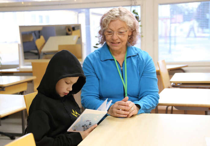 Helena Kinnunen aloitti viime syksynä lukumummina Auran yhtenäiskoulussa. Lasten kanssa puuhastelu on neljän lapsen äidille ja kahdeksan lapsenlapsen mammalle hyvin mieluisaa puuhaa. Tällä kertaa lukuseurana oli Aatu.