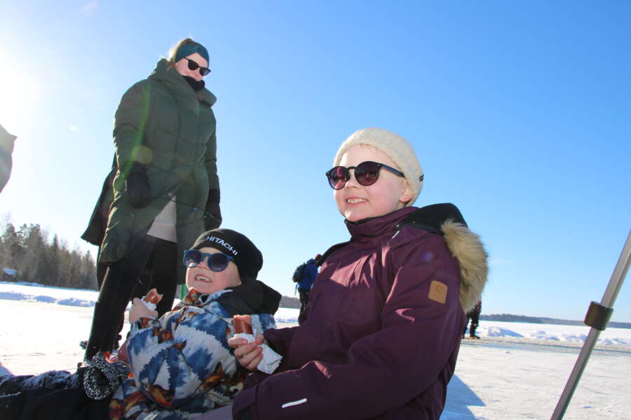 Iida, Siimon ja Seela Rantala nauttivat jääkarusellin keskellä paistetut makkarat. Mukana oli myös Edla Rantala, joka oli kuvaushetkellä pulkassa päiväunilla.